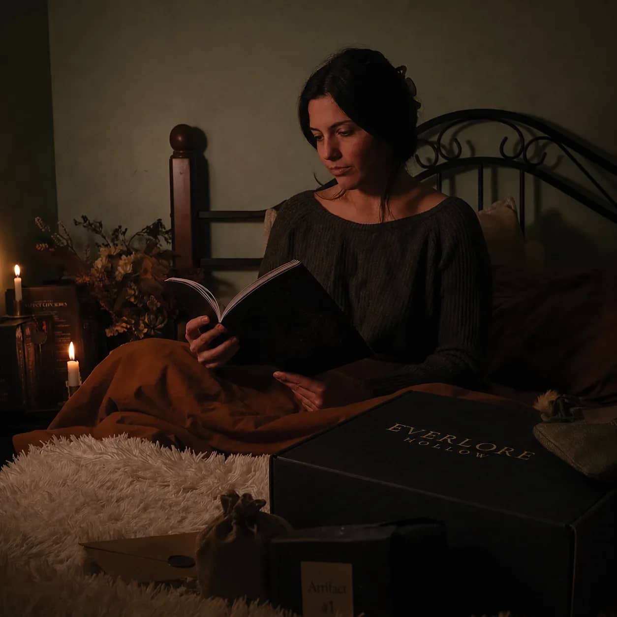 An Everlore Hollow candlelit reading scene with printed episodes, tea, and sealed artifacts